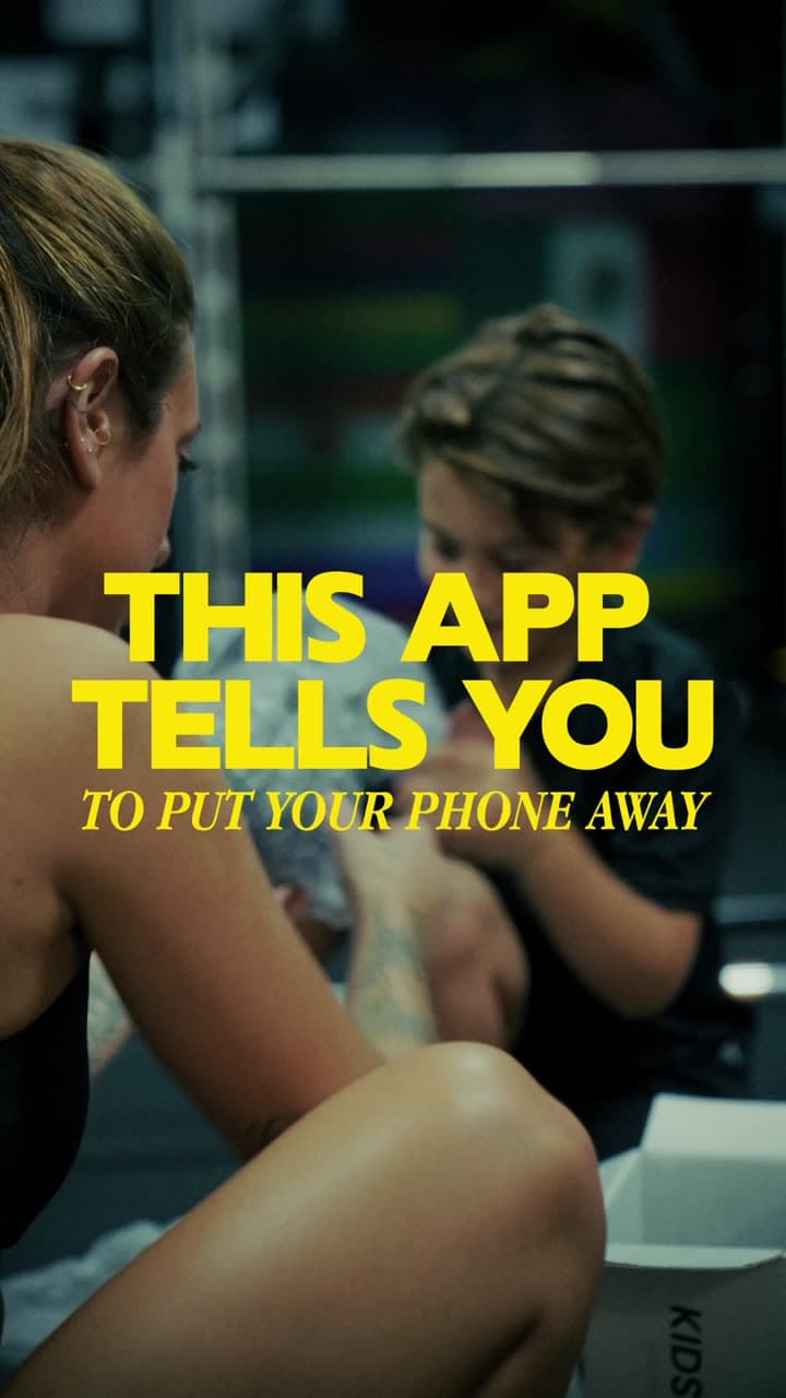 This app tells you to put your phone away. A parent and kid at the start of a BabyGains Play workout in the gym.